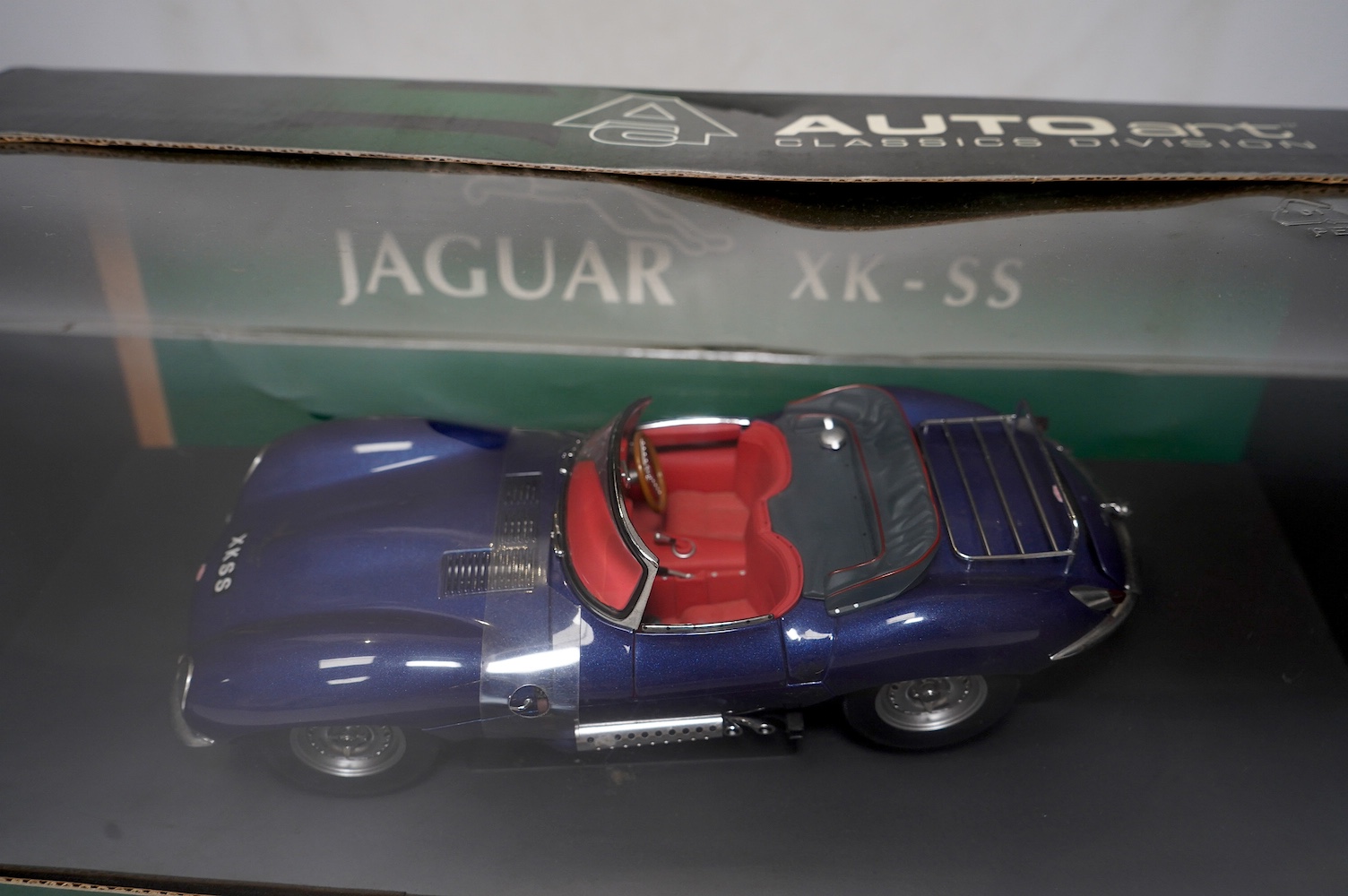 Two boxed AutoArt Classics Division 1:18 scale diecast cars; a Jaguar XKSS and a Jaguar C Type. Condition - good.